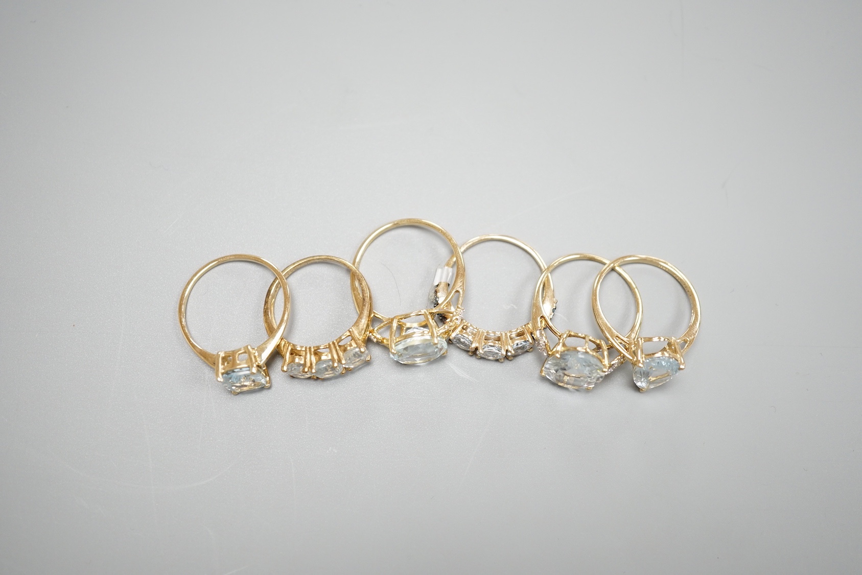Five assorted modern 9ct gold and aquamarine set dress rings , gross 11.4 grams and one 925 ring.